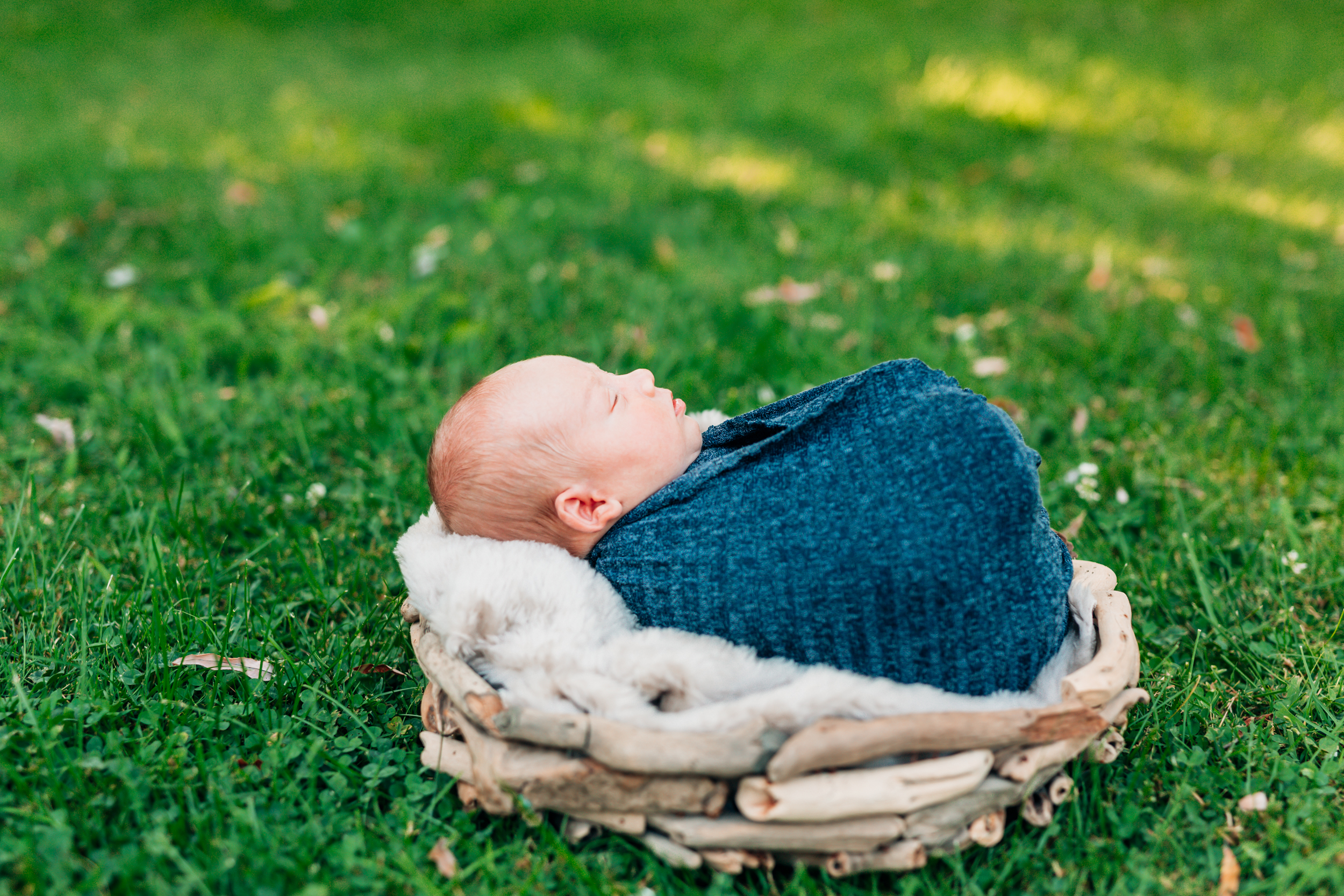 baby wrapped up in a simple wrap for an outdoor newborn session