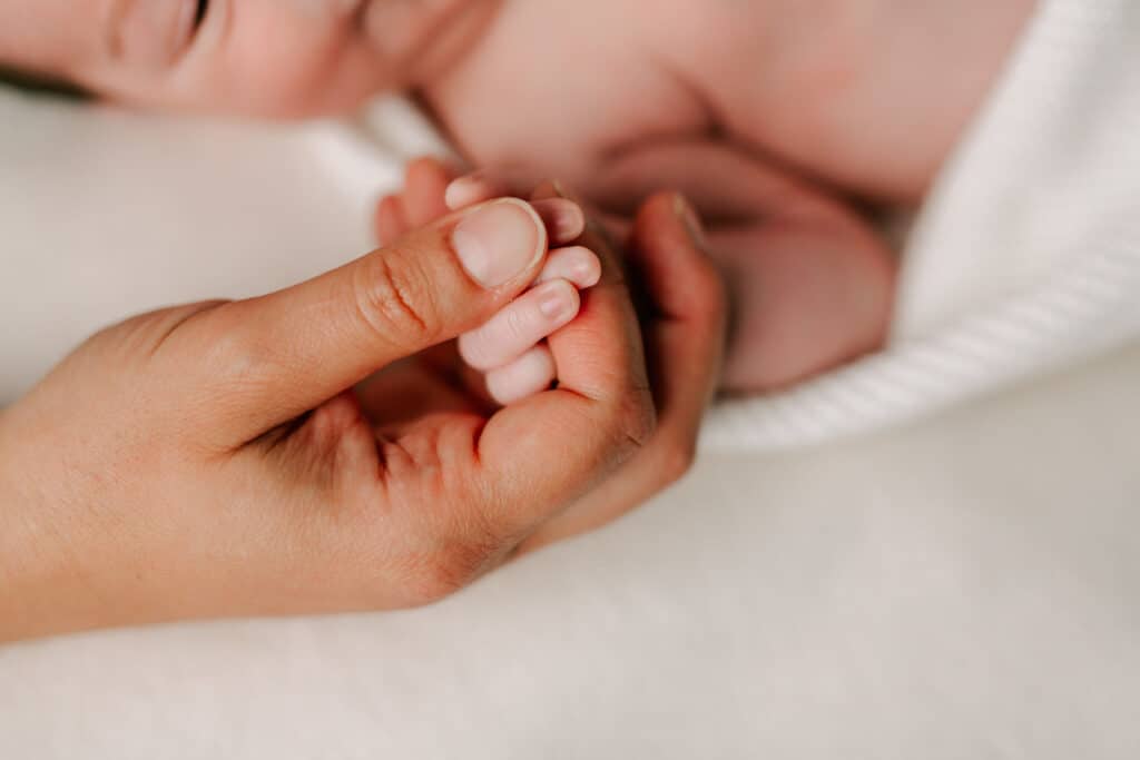 mother's hands holding her newborn baby's Guelph Midwives